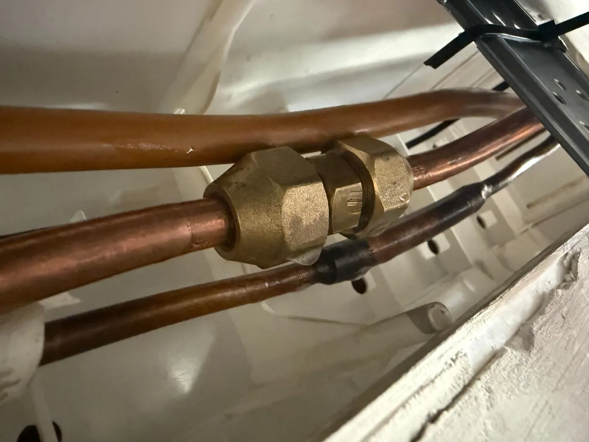 Due tubi in rame di un condizionatore uniti con un raccordo filettato in ottone invece che saldati